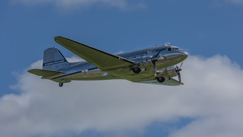 Vintage silver aircraft flying over clouds